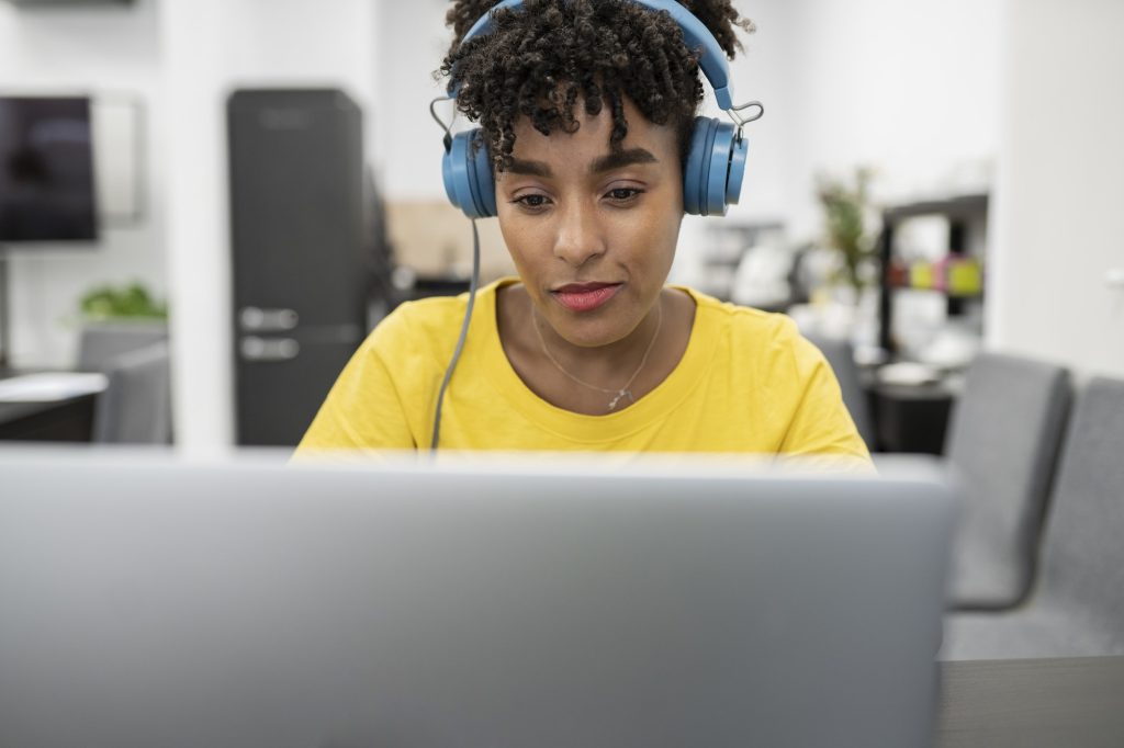 pretty afro woman working with headphones answering clients